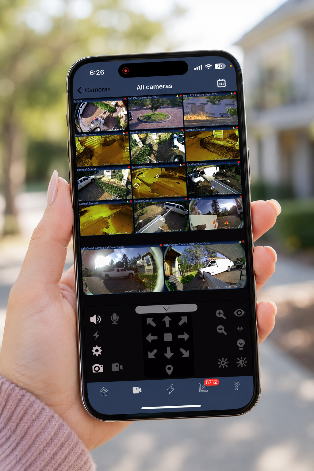 Person holding phone showing live camera feeds from surveillance trailer
